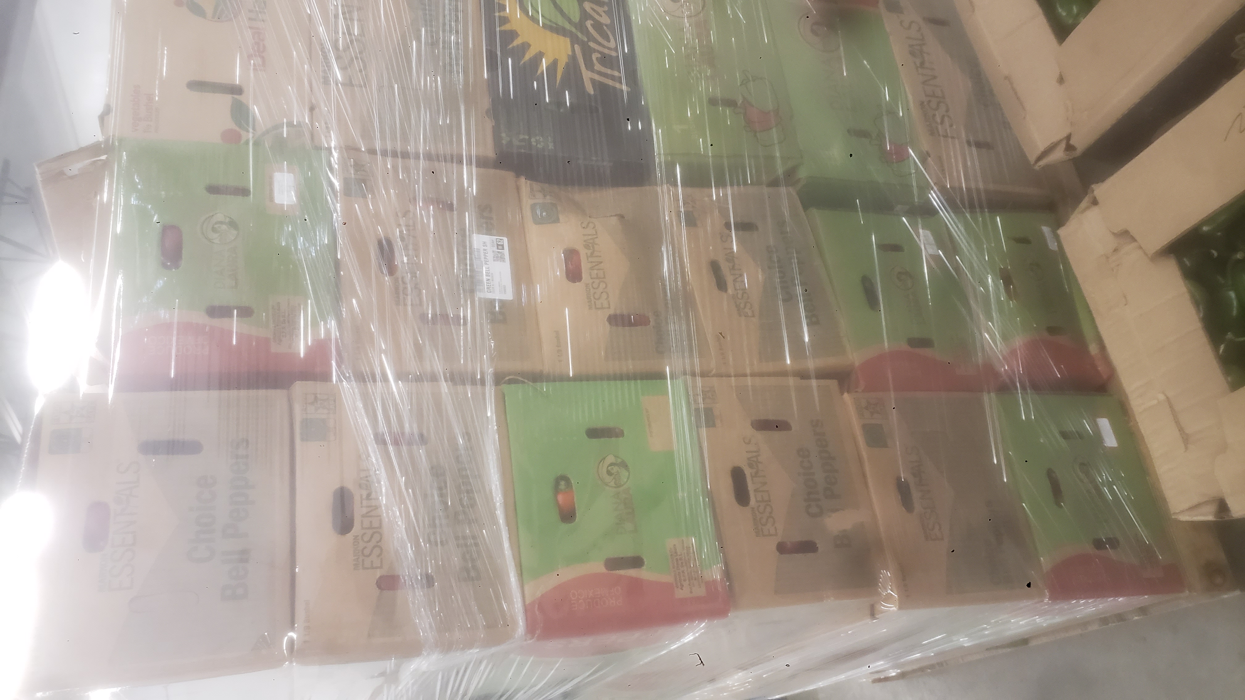 Stack of produce boxes in plastic wrap on pallets.